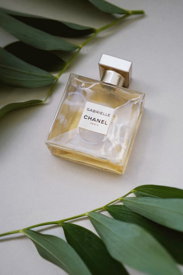 A Bottle of Gabrielle Chanel Paris perfume with some plants beside it